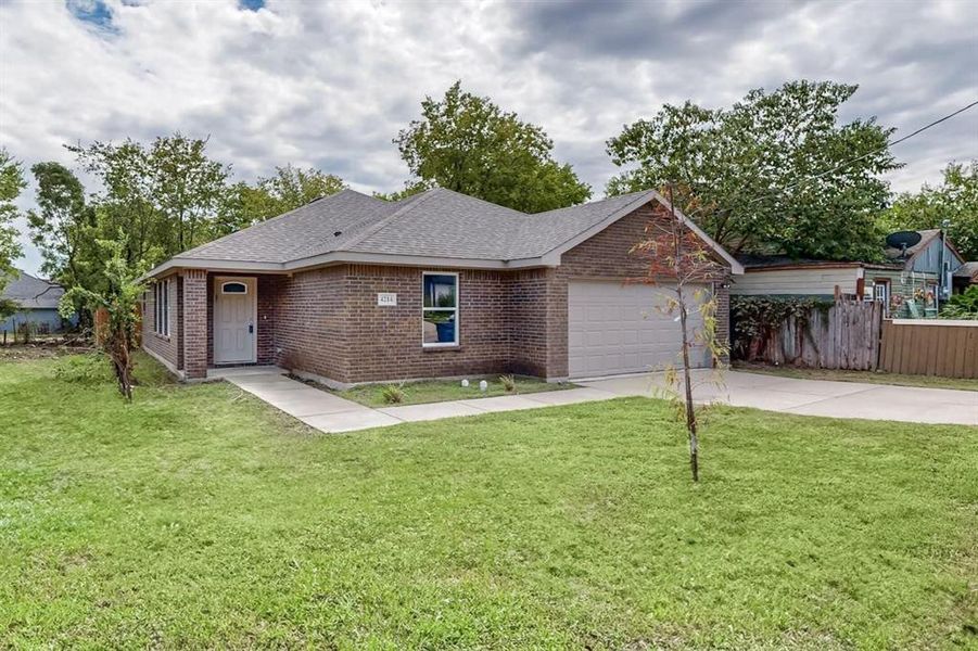 Ranch-style house with a garage and a front lawn