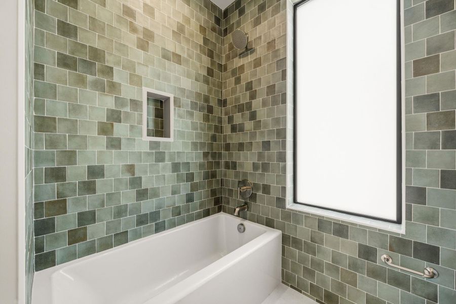 A deep soaking tub within a beautifully tiled alcove creates a tranquil bathing experience. A deep soaking tub within a beautifully tiled alcove creates a tranquil bathing experience.