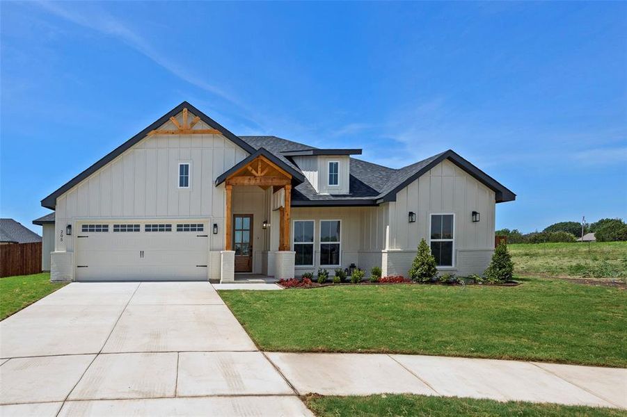 View of front of property featuring a garage and a front yard