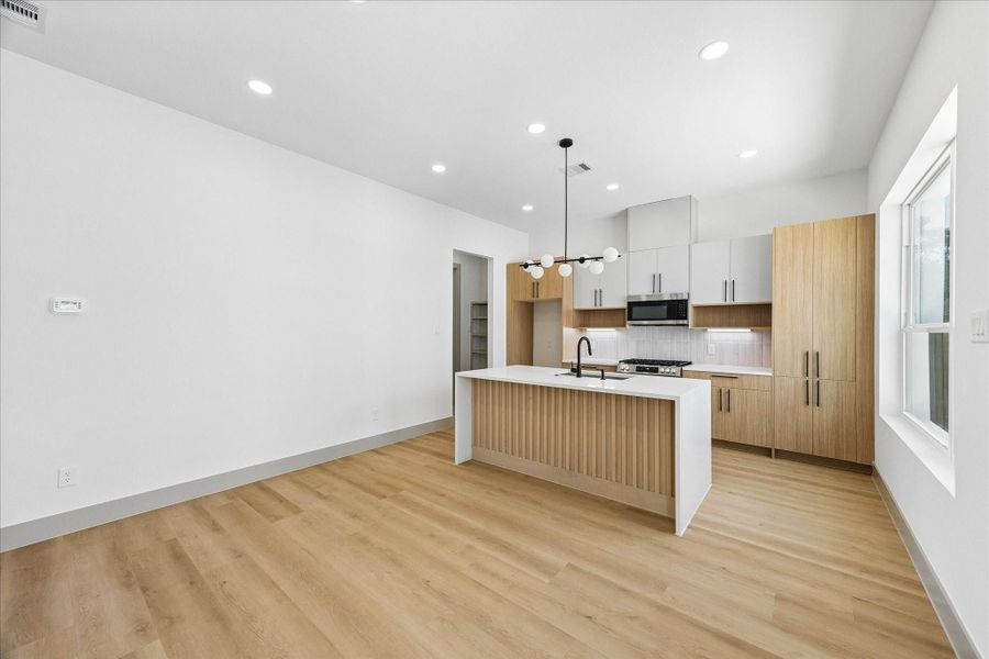 Designed for gathering, the open kitchen and dining area combine clean lines, natural textures, and generous entertaining space beneath soaring ceilings.