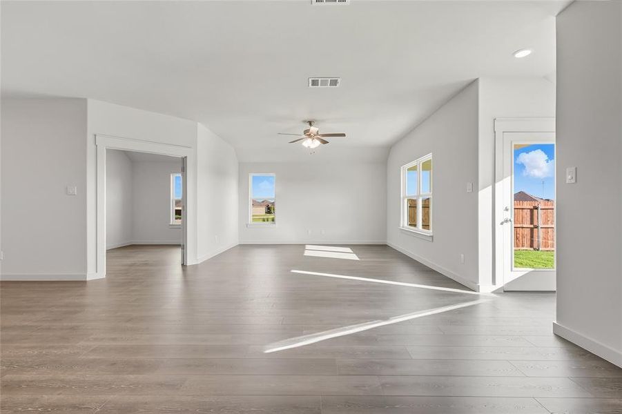 Unfurnished living room featuring wood finished floors, ceiling fan, and recessed lighting Unfurnished living room featuring wood finished floors, ceiling fan, and recessed lighting