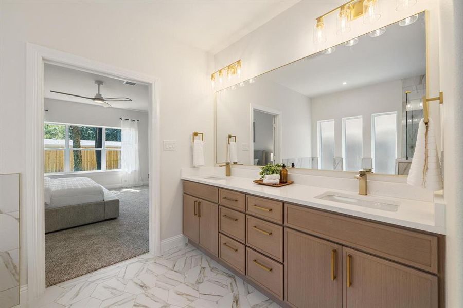Ensuite bathroom featuring double vanity, a ceiling fan, and light marble finish flooring Ensuite bathroom featuring double vanity, a ceiling fan, and light marble finish flooring