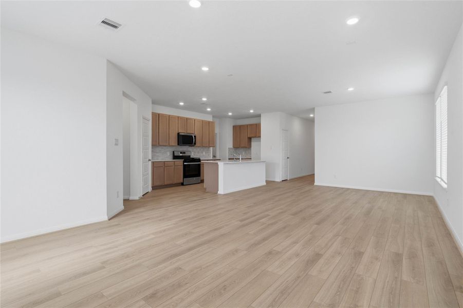 Stunning open-concept design seamlessly connecting the living, dining, and kitchen areas—perfect for both everyday living and entertaining!