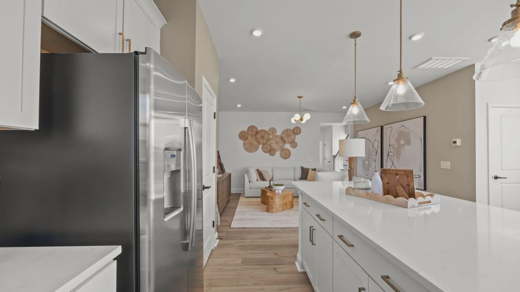 The Rochester Plan by DRB homes kitchen with white cabinets, silver appliances and gold features in Charlotte, NC.