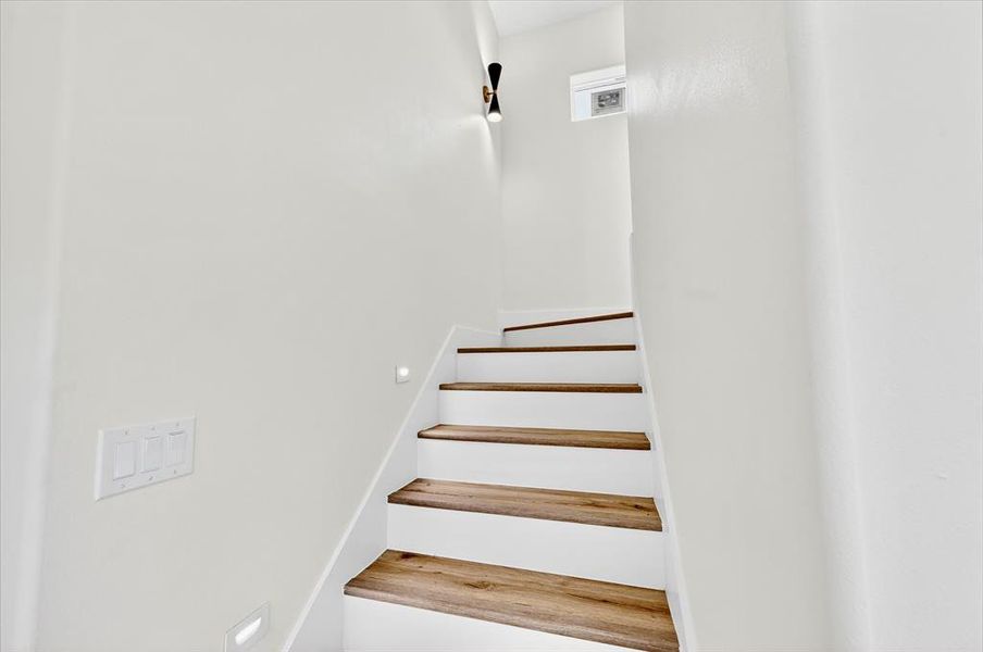 Staircase featuring wood-finish treads and white risers