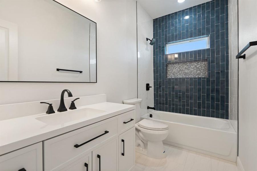 Full bath featuring vanity, bathing tub / shower combination, and light tile patterned floors Full bath featuring vanity, bathing tub / shower combination, and light tile patterned floors