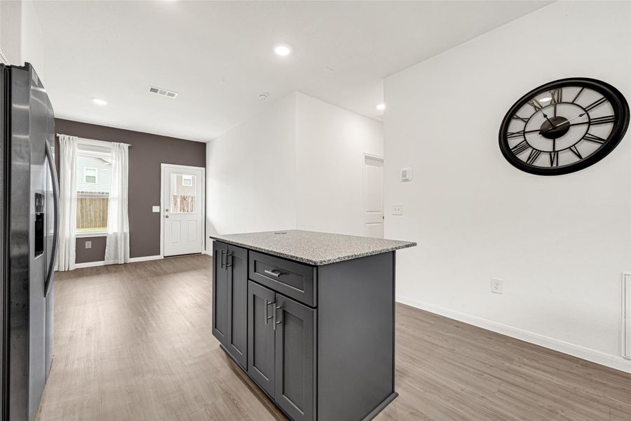 Beautiful open-concept kitchen highlighting a spacious central island with bar seating capability.
