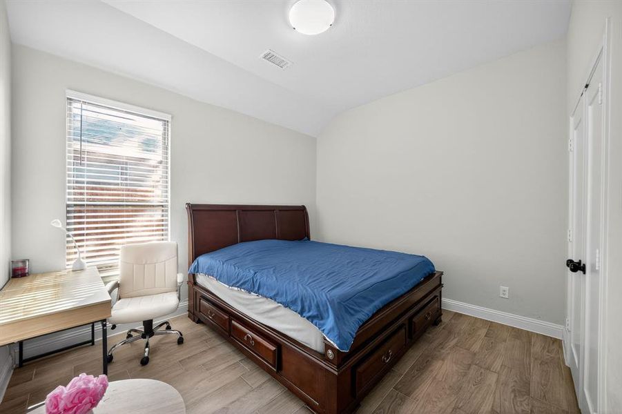 Bedroom featuring wood finished floors and lofted ceiling