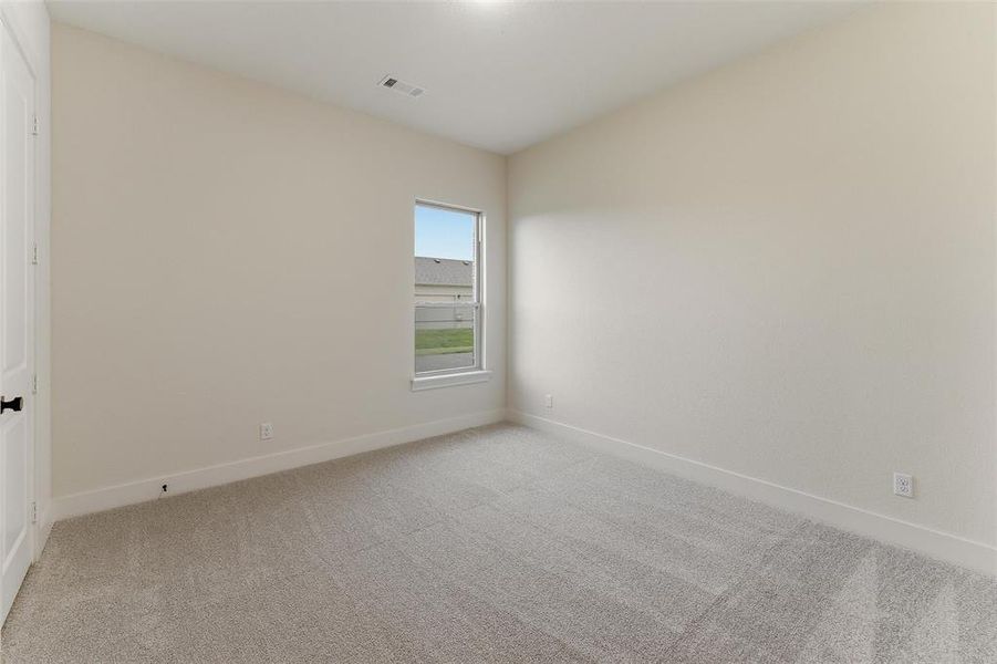Neutral-toned room featuring a single window with white trim, light gray carpet, and white baseboards Neutral-toned room featuring a single window with white trim, light gray carpet, and white baseboards