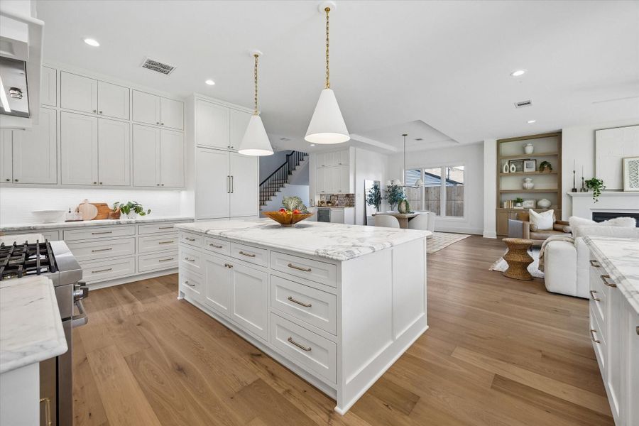 Quartz island anchors the kitchen with deep drawer storage and seating that keeps everyone connected to the living space. Designer pendant lighting, and seamless views into the family room, deliver an ideal layout for everyday living and large scale entertaining. **PREVIOUS BUILDER WORK** Quartz island anchors the kitchen with deep drawer storage and seating that keeps everyone connected to the living space. Designer pendant lighting, and seamless views into the family room, deliver an ideal layout for everyday living and large scale entertaining. **PREVIOUS BUILDER WORK**