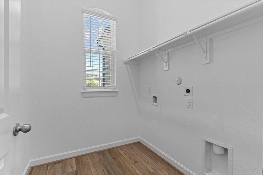 Utility room features built-in shelving, washer and dryer connections, and a bright window for natural light to tell that blue sock from the black sock!