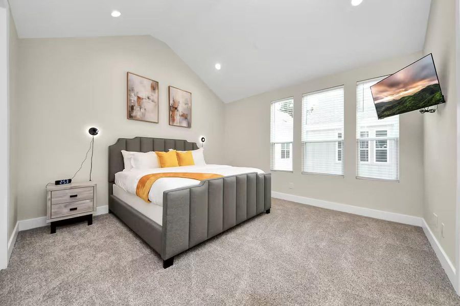 High ceilings and three windows give the primary bedroom an airy feel with plenty of natural light throughout the day.