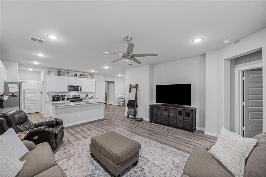 Living room featuring ceiling fan and light hardwood / wood-style flooring