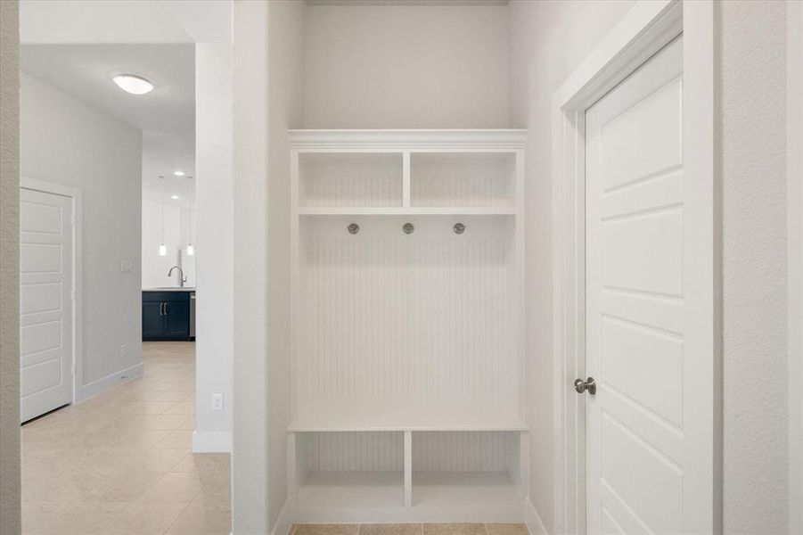 Mudroom area is just off garage entry and features built-in shelfing, bench and hooks.