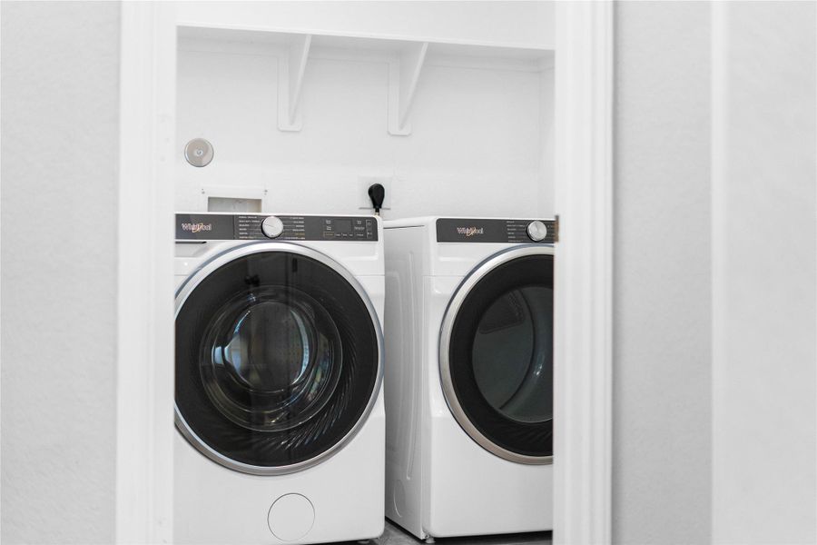 This dedicated laundry room comes equipped with a washer and dryer set, ready for immediate use.