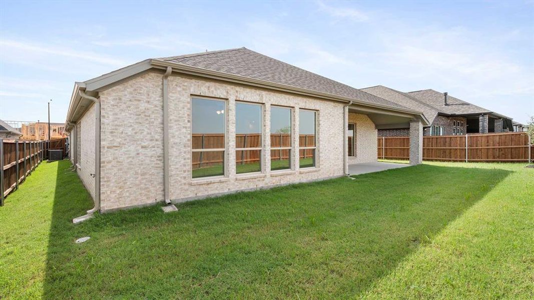 Rear view of property featuring a yard and a patio