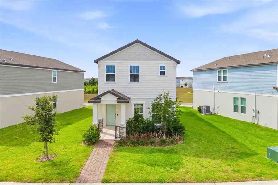 Front exterior of a new home in Highland Ridge, Winter Garden, FL, highlighting curb appeal (Image 22).