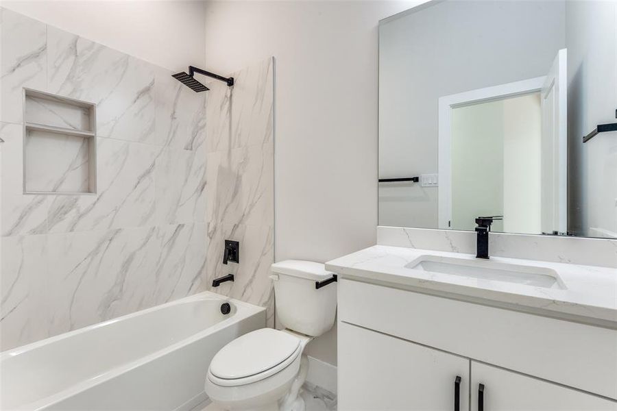 Full bathroom with vanity, toilet, and tiled shower / bath combo