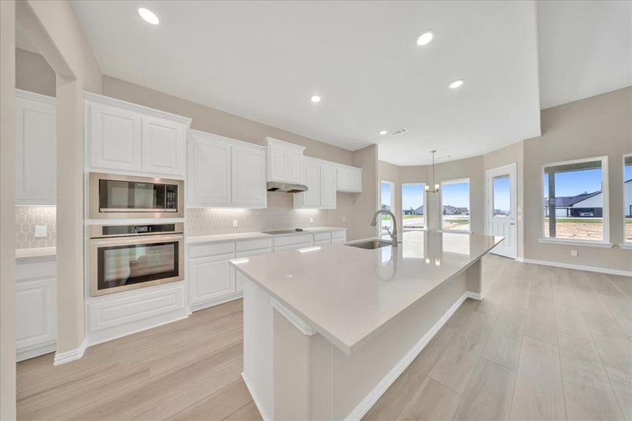 Kitchen featuring oven, built in microwave, light wood-style flooring, backsplash, and recessed lighting Kitchen featuring oven, built in microwave, light wood-style flooring, backsplash, and recessed lighting