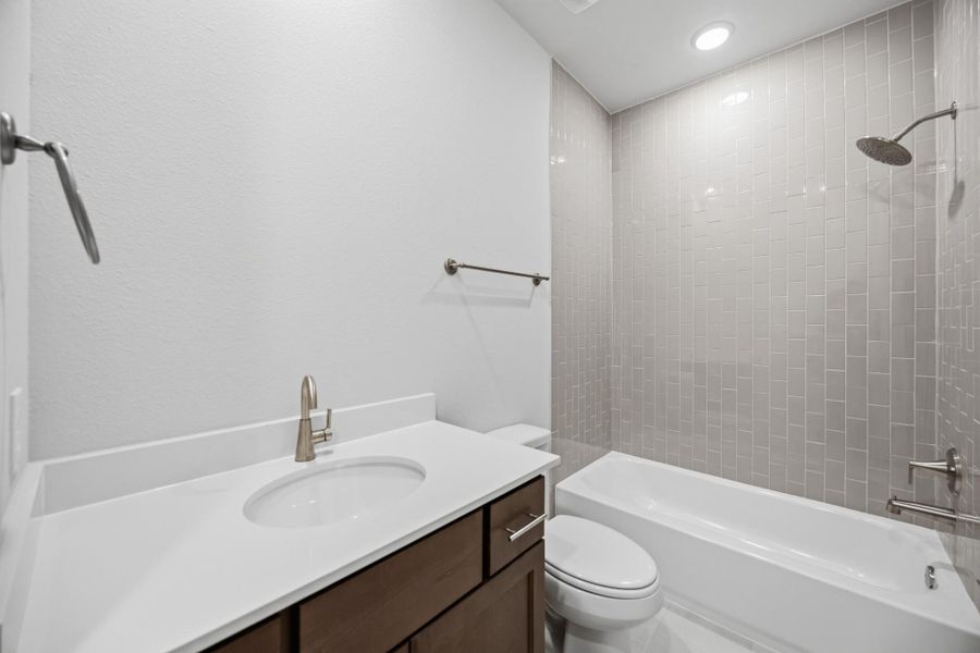 Shared convenience with a touch of classic design, this hall bathroom serves the game room and secondary bedrooms effortlessly.