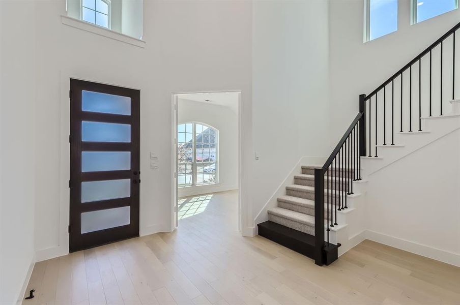 Foyer featuring a high ceiling and light wood-type flooring