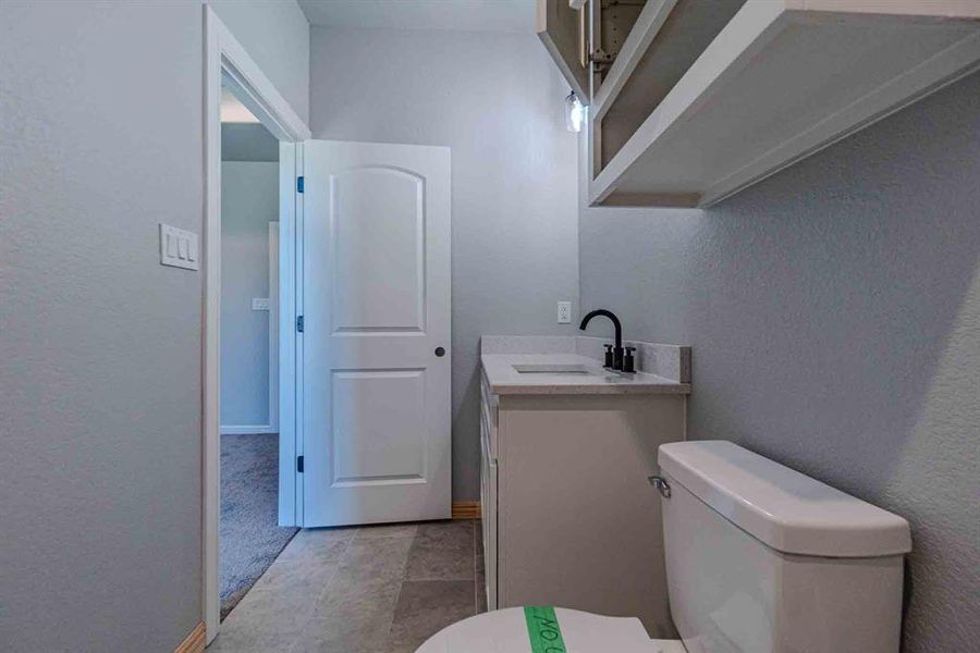 Bathroom with a textured wall and vanity Bathroom with a textured wall and vanity