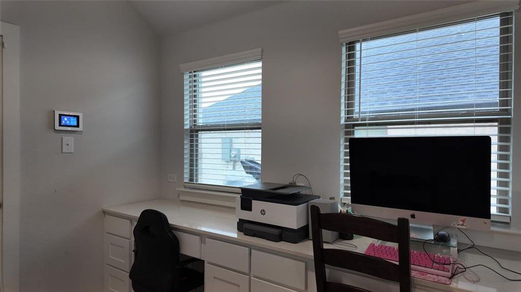 This property features a dedicated workspace with built-in cabinetry, a countertop, and two windows providing natural light