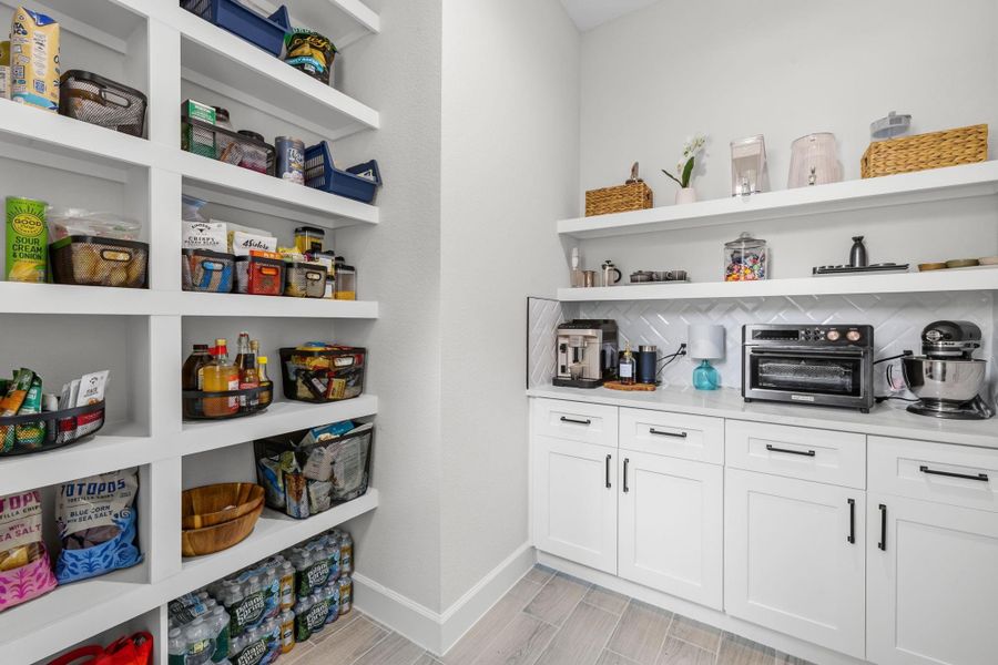 WALK IN PANTRY - Walk-in pantry offers custom built-in shelving, cabinetry, and generous storage designed to keep everyday essentials beautifully organized.