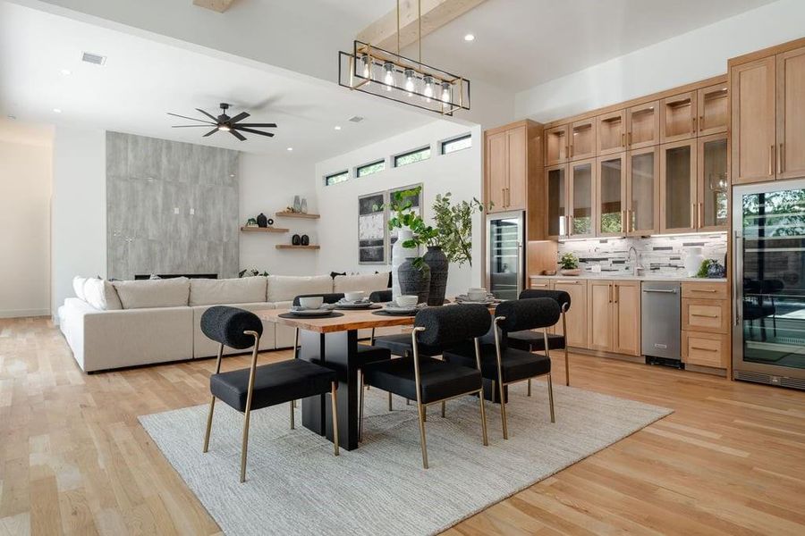 Dining space featuring  beam ceiling, sink, and light hardwood floors