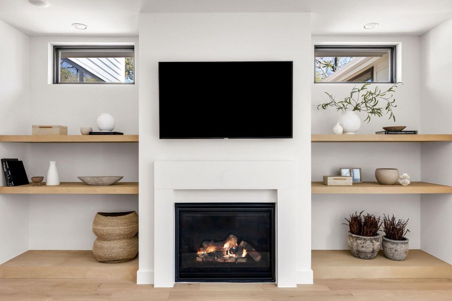 Detailed view of wood finished floors and a glass covered fireplace
