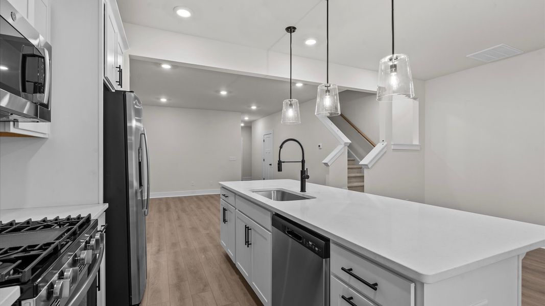 Tasteful design meets functional luxury in this kitchen with a 9-foot island and modern pendant lighting