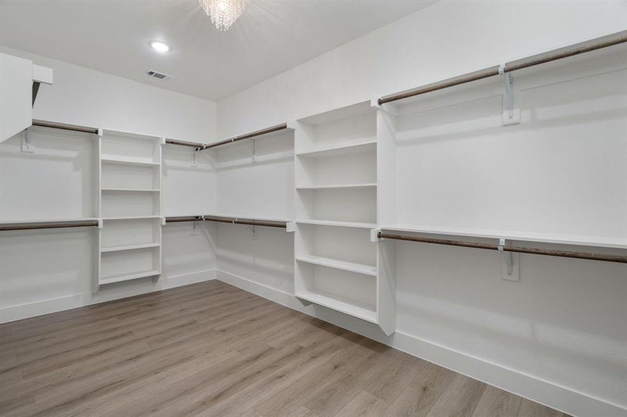 Walk in closet with light wood finished floors Walk in closet with light wood finished floors
