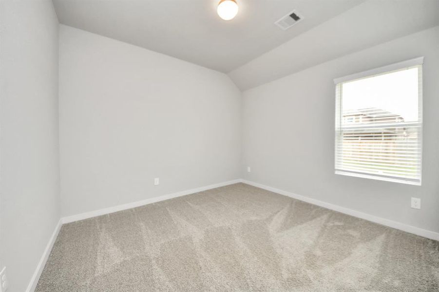 Secondary bedroom features plush carpeting, large windows that let in plenty of natural light, bright paint, and spacious closets.