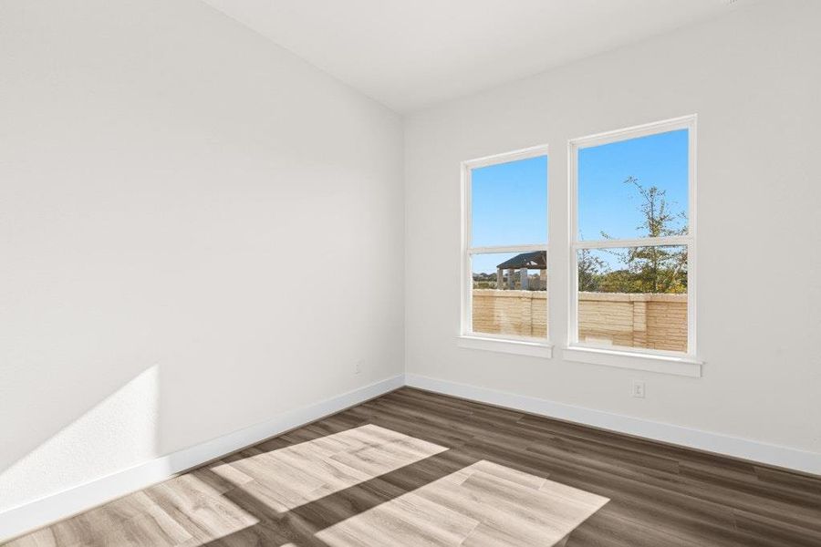 Spare room featuring dark wood-style flooring and baseboards Spare room featuring dark wood-style flooring and baseboards