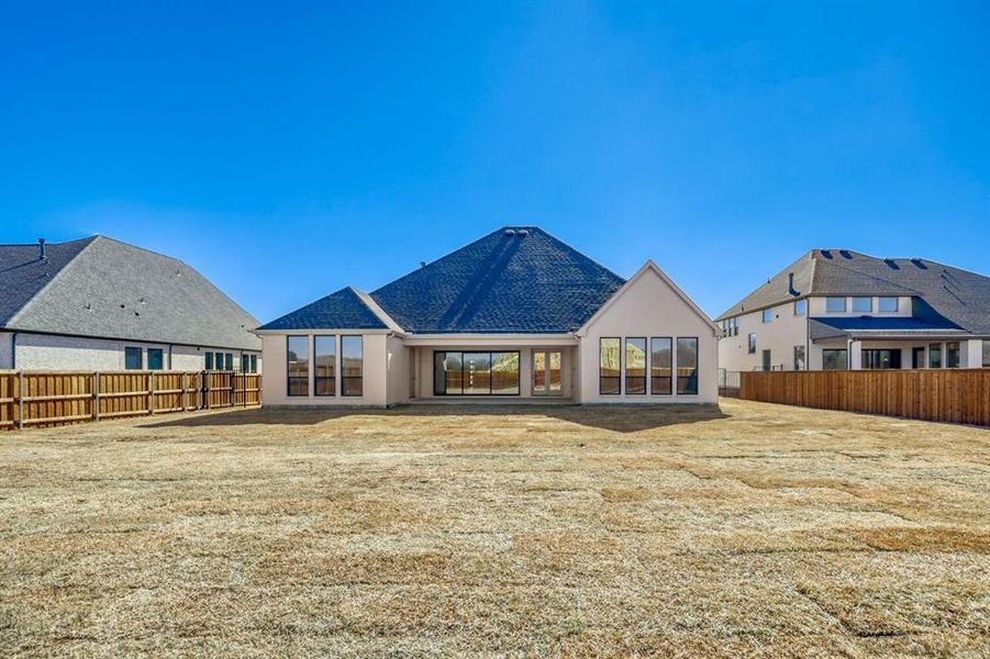 Rear view of house with a fenced backyard, a patio area, and stucco siding