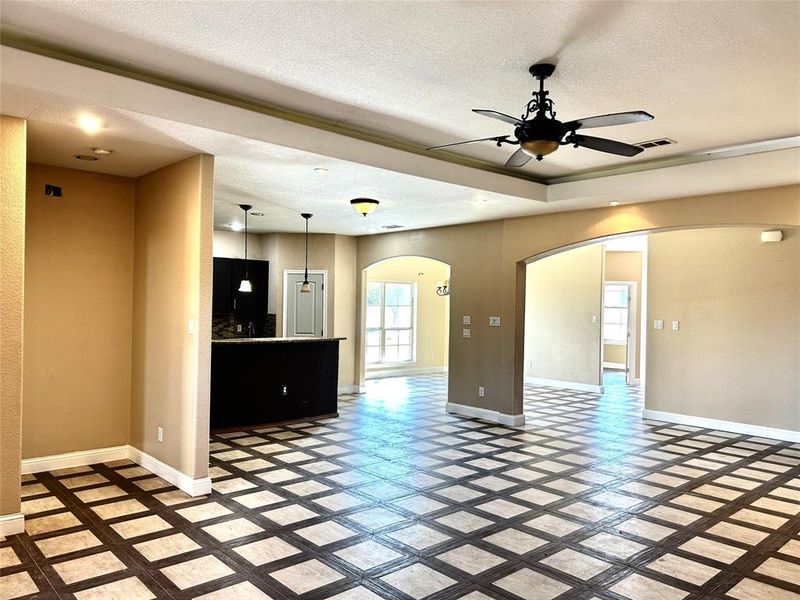 Unfurnished living room featuring ceiling fan and a textured ceiling