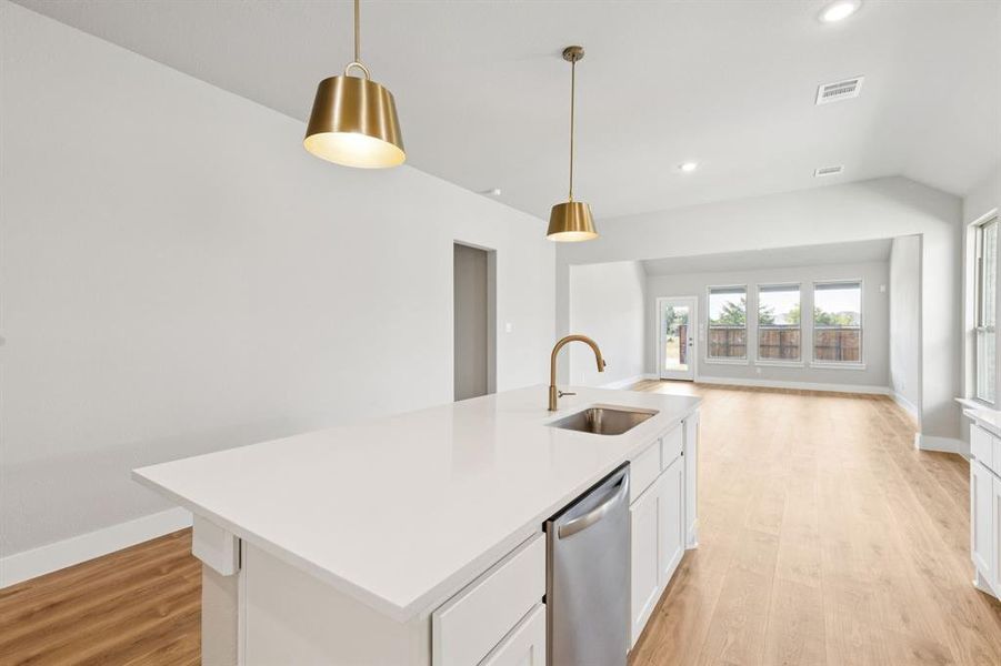 Kitchen featuring a kitchen island with sink, recessed lighting, light wood-style floors, decorative light fixtures, and white cabinetry