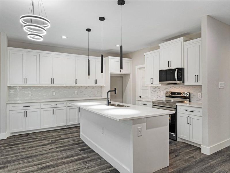 Kitchen featuring white cabinetry, a center island with sink, and appliances with stainless steel finishes