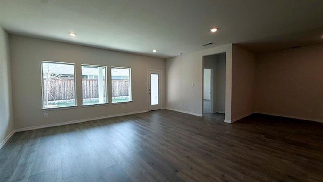 Empty room featuring dark wood-type flooring and recessed lighting