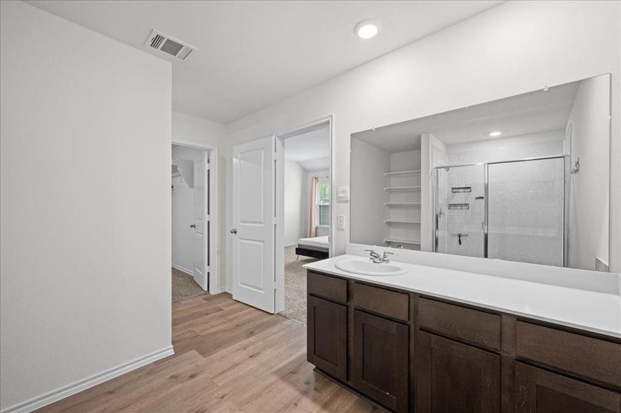 Bathroom featuring a shower stall, light wood finished floors, vanity, and recessed lighting Bathroom featuring a shower stall, light wood finished floors, vanity, and recessed lighting