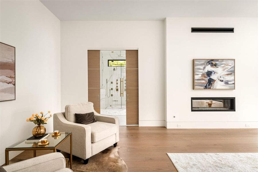 Primary suite showcasing a clean architectural transition into the bath through sliding doors.