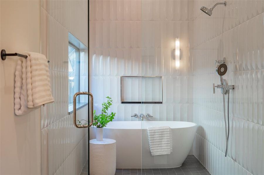 Bathroom featuring separate shower and tub and tile walls