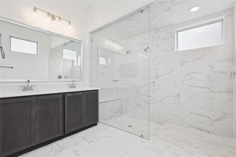 Bathroom featuring tile patterned flooring, tiled shower, and vanity