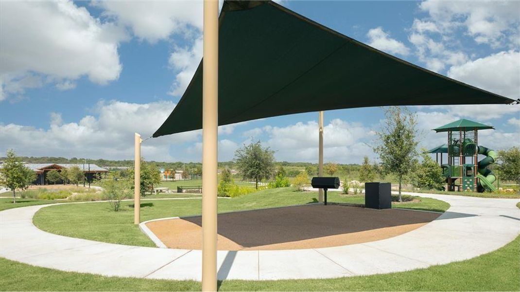 A community gathering space features a shaded picnic area alongside winding pathways and a vibrant playground. A community gathering space features a shaded picnic area alongside winding pathways and a vibrant playground.
