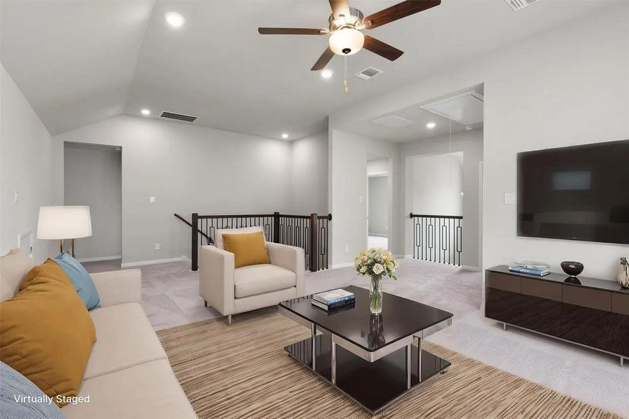 An inviting open-concept living area with vaulted ceilings and elegant railing detail awaits.