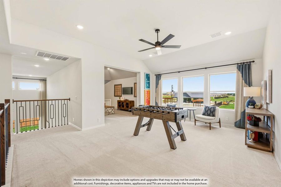 Upstairs game room with foosball table, carpet flooring, ceiling fan, and large windows overlooking backyard