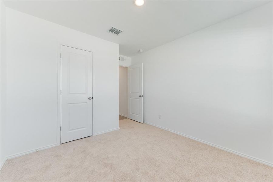 Unfurnished bedroom with light carpet