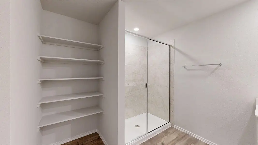 Full bathroom featuring light wood-type flooring and a shower stall Full bathroom featuring light wood-type flooring and a shower stall