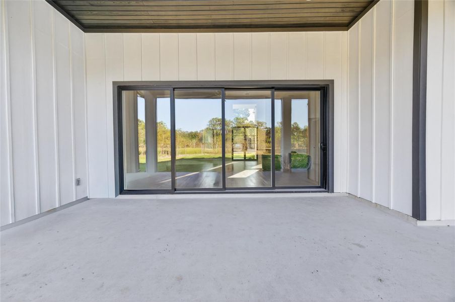 Oversized sliding glass doors create a seamless indoor-outdoor connection from the covered patio to the main living areas. **Images are from a previously completed project. **