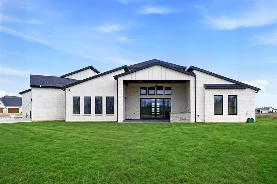 Expansive covered patio designed for indoor-outdoor living, overlooking the spacious backyard and scenic farmland beyond. The outdoor kitchen will be completed prior to closing, creating the perfect space for entertaining. Grass is digitally enhanced.